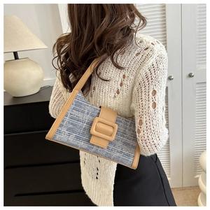 Détail du sac baguette en tweed bleu et blanc avec bandoulière en cuir et boucle