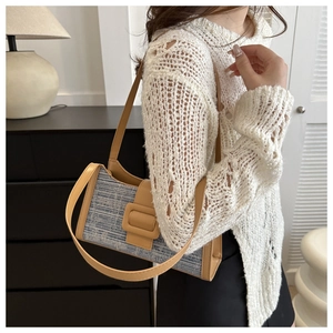 Détail du sac à bandoulière en denim tissé avec sangle en cuir marron et boucle carrée