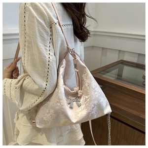 Detail of light pink tote bag with retro jacquard fabric and silver bow charm