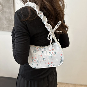 Sac hobo à imprimé floral avec bandoulière plissée et nœud porté par un mannequin