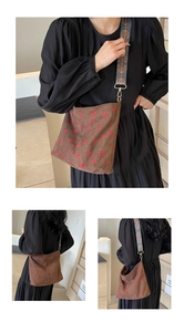 Detailed close-up of brown corduroy bucket bag with red strawberry print and jacquard strap