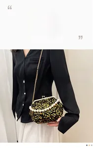 Detail of sequin evening bag featuring pearl handle and retro metal clip closure