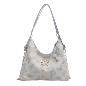White tote bag with blue butterfly print, silver bow buckle, and chain strap detail
