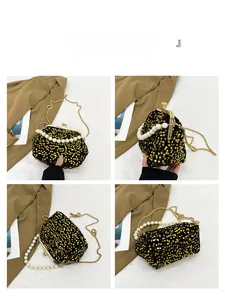 Detail view of sparkly gold sequin evening bag with pearl handle and metal chain