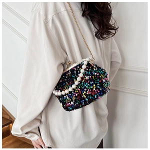 Detail of colorful sequin clutch bag with pearl handle and metal chain for evening wear