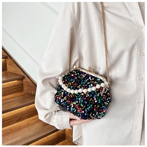 Detail of colorful sequin evening bag with pearl handle and golden chain on model