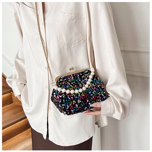 Macro view of a colorful sequined shell bag with golden clasp and pearl handle detail