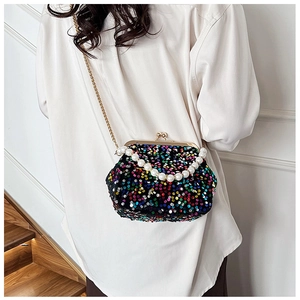 Macro shot of colorful sequins and pearl handle on a trendy metallic clasp evening bag