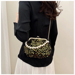 Detail of sequin clutch with pearl handle and golden chain strap on a model