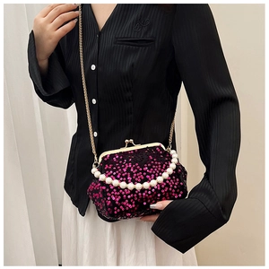 Detail of sequined purple clutch bag with large pearl handle and gold chain strap