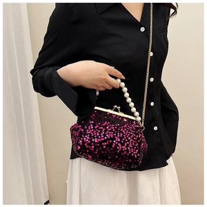 Detail of mini shell bag with pink sequins, pearl handle and golden chain strap