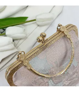 Dettaglio della montatura in metallo dorato e chiusura a sfera su borsa in jacquard