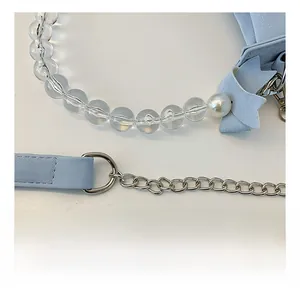 Detail of light blue bow accessory with acrylic beads and silver chain hardware