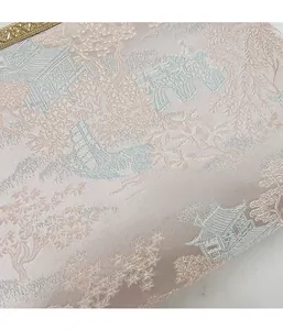 Dettaglio del tessuto jacquard rosa con ricami classici e cornice dorata