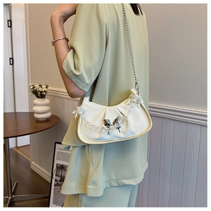 Détail du sac croissant plissé blanc avec fermoir papillon argenté et perles