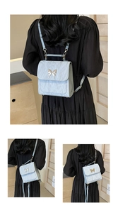 Detail of light blue wrinkled texture backpack featuring a metal butterfly buckle