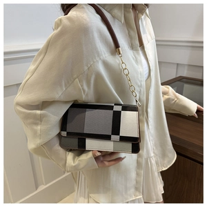 Detail of color-block flap bag with grid design and gold chain leather strap