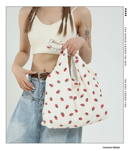 Dettaglio della borsa tote in maglia con motivo a fragola e superficie in tessuto operato