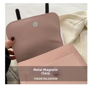 Detail of pink leather backpack featuring a magnetic snap closure and front pocket
