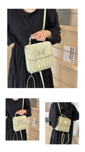 Detail of mint green ruffled texture shoulder bag with silver butterfly buckle closure