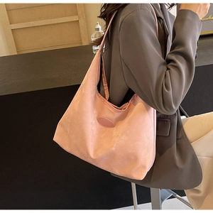 Détail du grand sac cabas rose effet daim avec écusson ovale et texture mate et douce