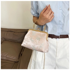 Dettaglio ravvicinato della borsa a conchiglia in jacquard vintage con manico dorato