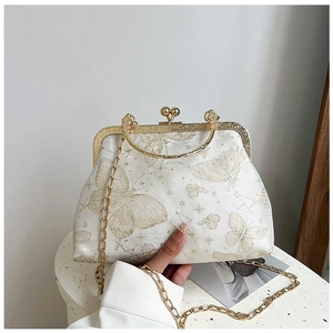Dettaglio del tessuto jacquard a farfalla e telaio dorato di una borsa vintage a catena