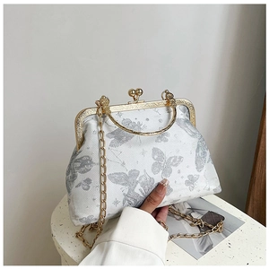 Dettaglio borsa vintage in broccato con farfalle argentate e chiusura in metallo dorato