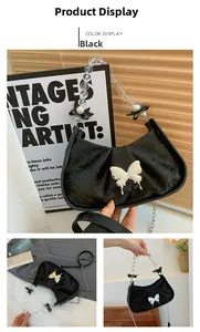 Detail of black pleated crescent bag with silver butterfly buckle and beaded strap