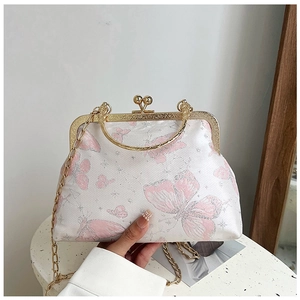 Dettaglio borsa in tessuto bianco con farfalle rosa e chiusura kiss-lock dorata