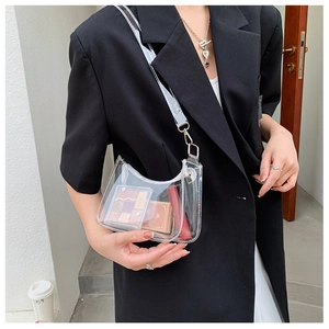 Detail of transparent PVC crescent crossbody bag showing interior storage and silver hooks