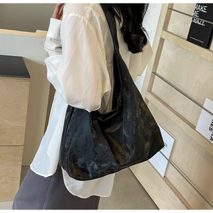 Gros plan d'un grand sac hobo gris en cuir texturé vintage avec une large bandoulière
