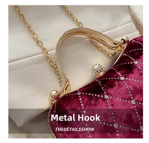 Detail of burgundy velvet clutch featuring silver glitter texture and gold diamond handle