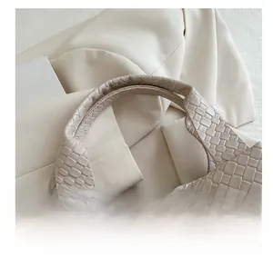 Close-up of the comfortable handle and crocodile embossed texture on beige handbag