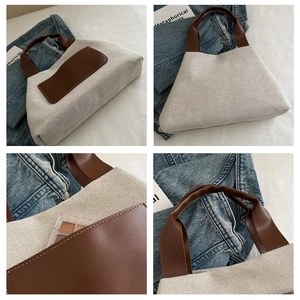 Detail view of large canvas tote bag with brown leather handles and front pocket