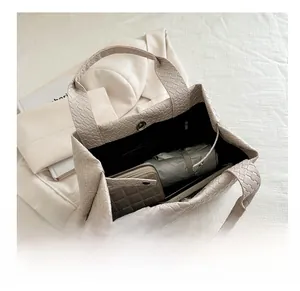 Interior view of large beige woven bucket bag showing spacious storage with personal items