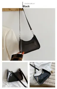 Detail of glossy black moon bag with silver hardware and detachable shoulder strap