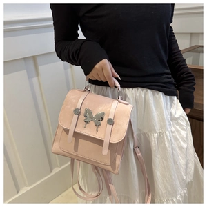 Detail of pink dual-use backpack with silver lava butterfly metal decor and slim straps