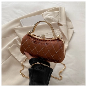 Close-up of brown velvet handbag with rhinestone lattice and golden metal handle