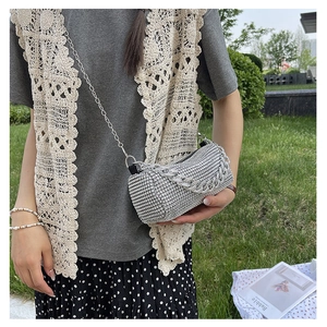Silver rhinestone cylinder evening bag with sparkling metal chain shown on model outdoors