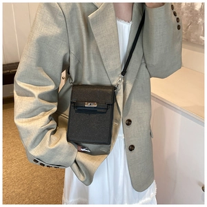 Detail of black glitter crossbody phone bag with silver metal twist lock and leather strap