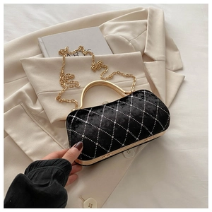 Close-up of black velvet quilted bag with sparkling crystals and gold metal handle