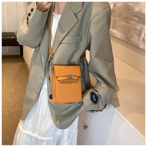 Vertical yellow mini crossbody bag with silver twist lock shown on a female model