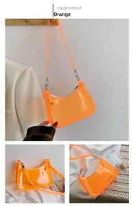 Detail of orange transparent PVC crescent underarm bag with silver zipper and hardware