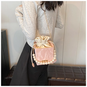 Détail du sac boîte rose marbré avec poignée en perles et bandoulière chaîne dorée