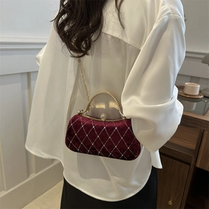 Detail of burgundy velvet handbag with quilted patterns and sparkling rhinestone studs