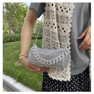 Detail of silver rhinestone cylinder handbag with metallic chain strap for parties
