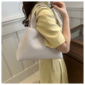 Detail of soft cream woven faux leather texture on a stylish minimalist tote bag