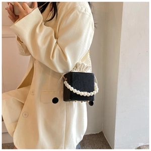 Détail du sac boîte noir avec poignée en perles et doublure à cordon sur un mannequin