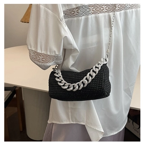 Detail of black rhinestone cylinder bag with silver chunky chain and metal strap